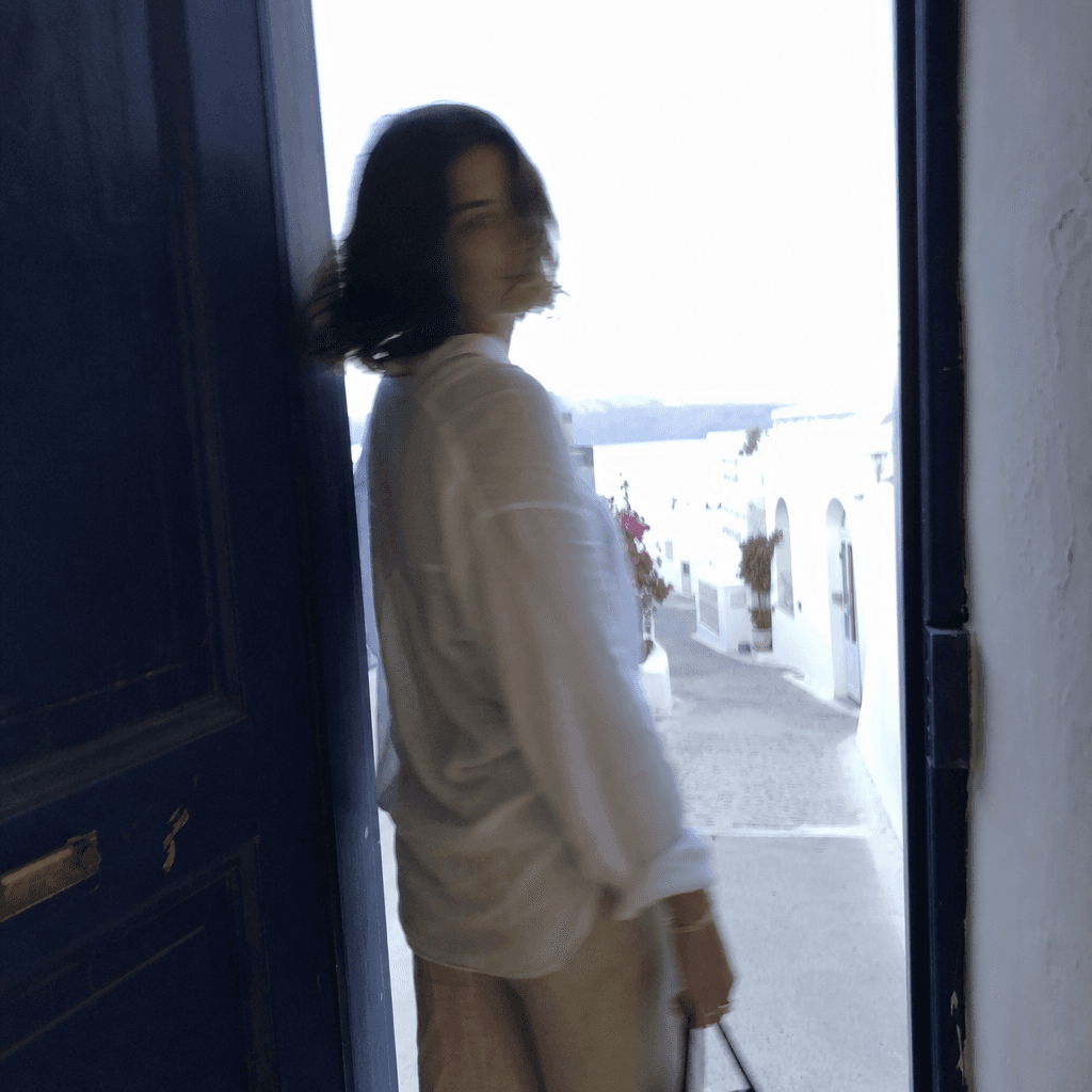 Photo légèrement floue dans l’embrasure d’une porte bleue, à contre-jour.